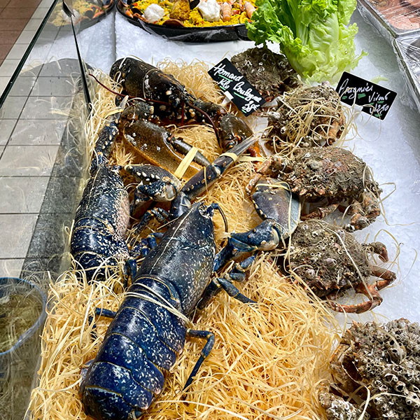 Meeresfrüchte und ein Hummer in einer Auslage in der Markthalle von Dijon