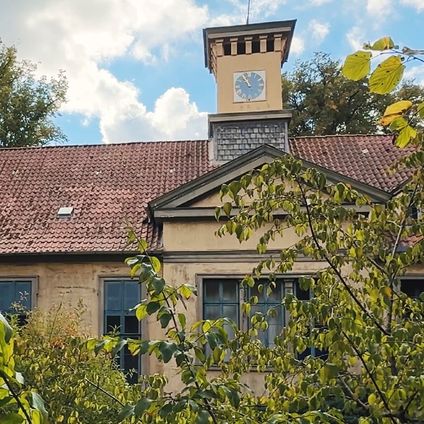 Jagdschloss Göhrde hinter spätsommerlichen Bäumen